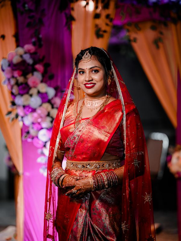 An Indian bride in red and gold wedding attire