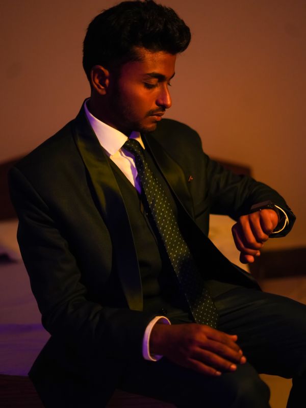 An Indian businessman in a dark suit checking his watch