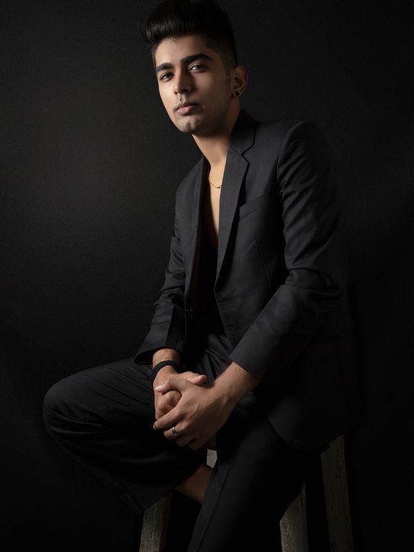 A man in a dark suit in moody low light